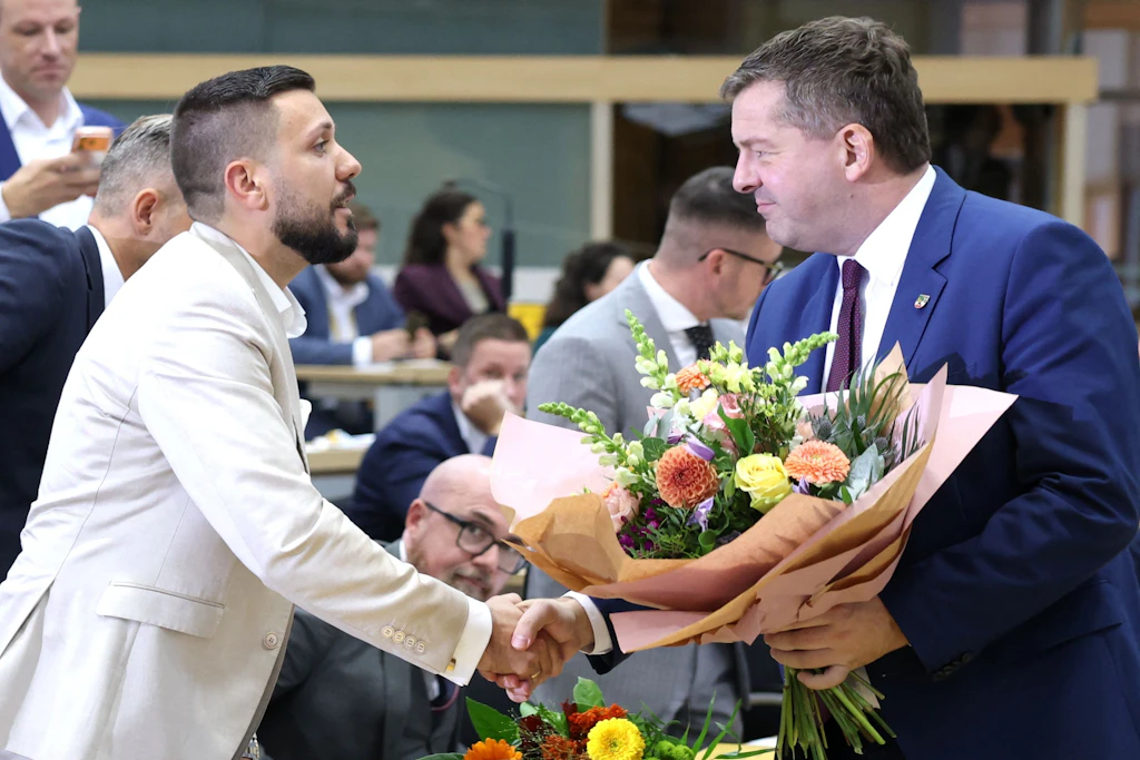 CDU-Ministerpräsident Sven Schulze (r.) überreicht dem frisch gewählten Landtagspräsidenten Tobias Rausch (AfD) einen Blumenstrauß.