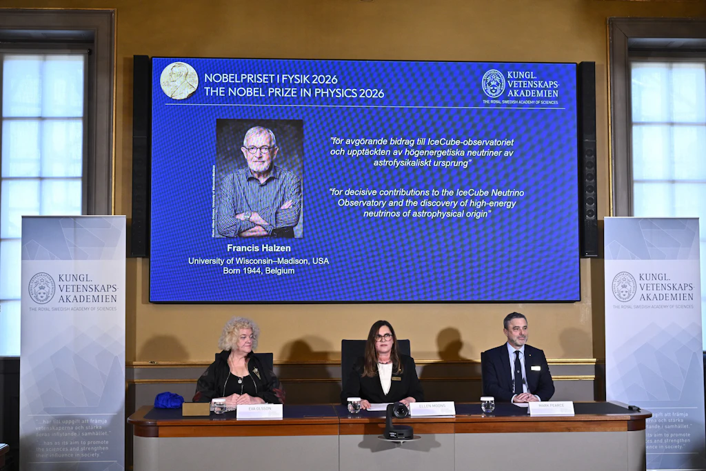 Auf dem Bildschirm ist ein Porträt von Francis Halzen zu sehen, während Eva Olsson, Ellen Moons und Mark Pearce ihn während einer Pressekonferenz in der Königlich Schwedischen Akademie der Wissenschaften in Stockholm, Schweden, als Preisträger des Nobelpreises für Physik 2026 bekannt geben.