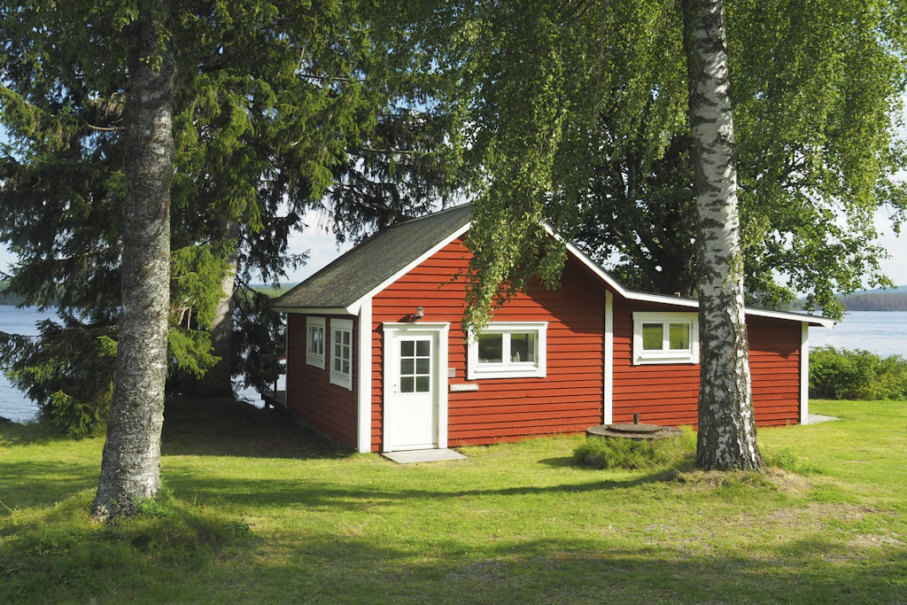 Rote Holzhütte am Seeufer: So sieht der Campingtraum in Schweden aus. Auf dem inserierten Platz am Orsasjön stehen acht Ferienhütten. (Symbolbild)