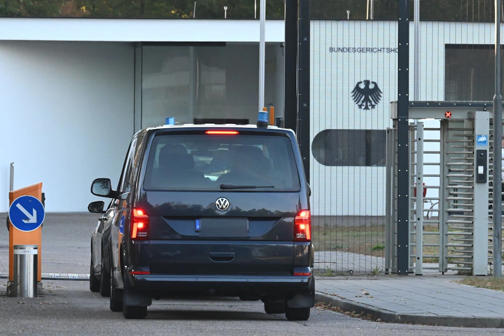 Zivile Polizeifahrzeuge mit Blaulicht fahren auf das Gelände des Bundesgerichtshofes.