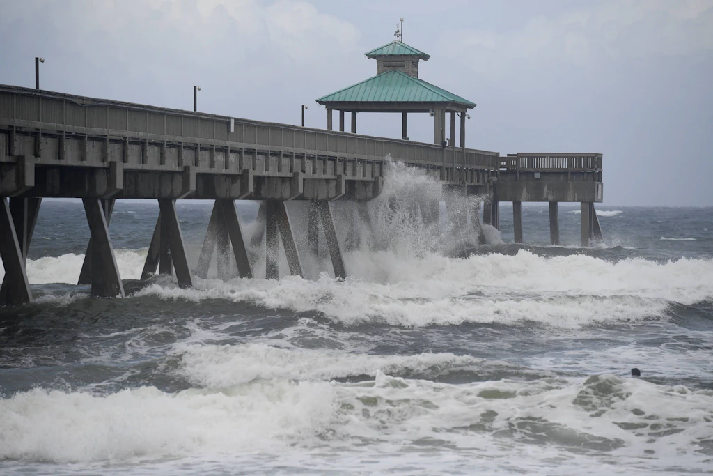 Hohe Wellen schlagen an der Küste Floridas gegen eine Seebrücke, während im August 2020 der gleichnamige Hurrikan „Isaias“ über die Region zieht.