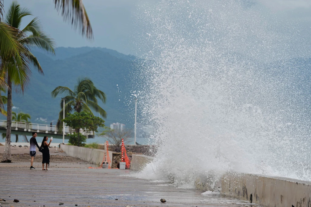 In Puerto Vallarta fotografieren Touristen die gegen die Küstenmauer schlagenden Wellen, während sich Hurrikan „Simon“ nähert.