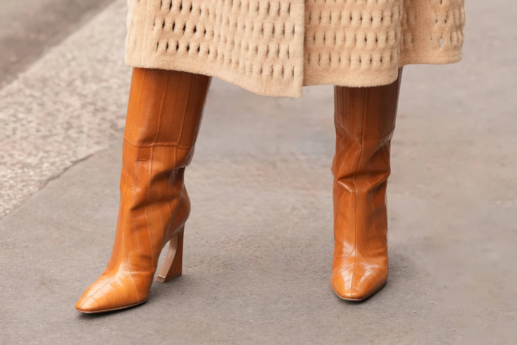 Streetstyle in Mailand: Eine Frau trägt karamellfarbene Lederstiefel von Fendi.