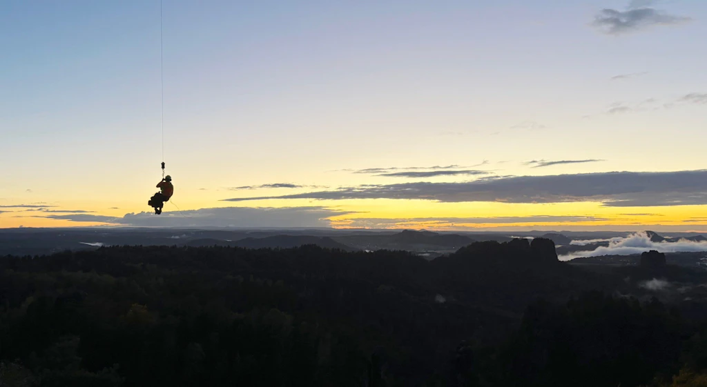 Bergwacht im Einsatz am Carolafels: Ein Rettungshubschrauber zieht bei Einbruch der Dunkelheit einen Verletzten aus den Affensteinen.