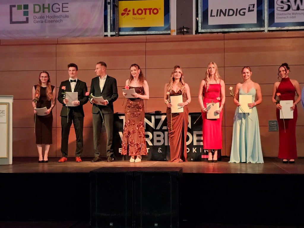 Abschlussfeier in Eisenach: Mehrere DHGE-Absolventen stehen bei der Zeugnisübergabe auf der Bühne der Werner-Aßmann-Halle.