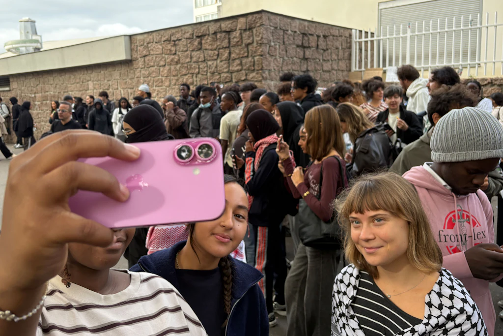 Greta Thunberg posiert am 13. Oktober 2026 vor dem Gymnasium Paul-Éluard in Saint-Denis bei Paris mit Jugendlichen für ein Selfie.