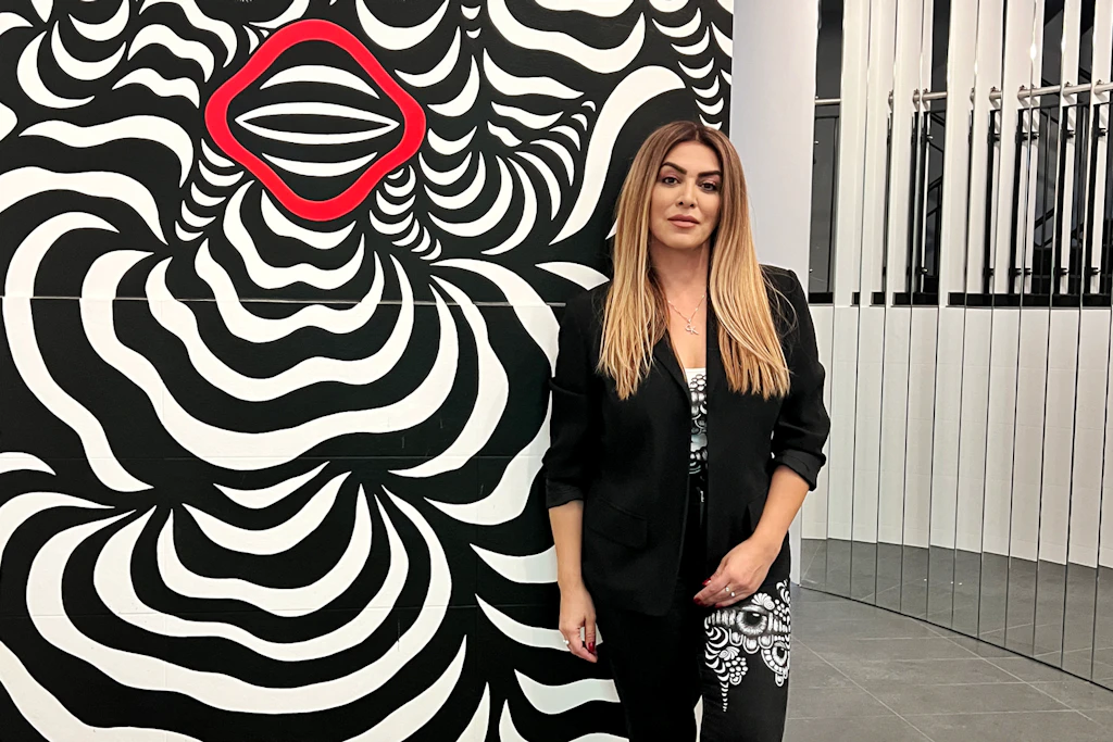 Gita Kurdpoor posiert vor einem Gemälde.