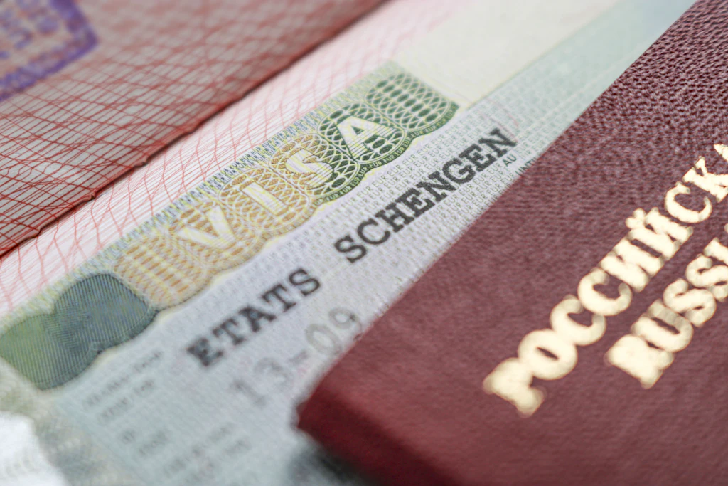 Ausschnitt eines Schengen-Visumstempels vor dem Hintergrund eines russischen Reisepasses