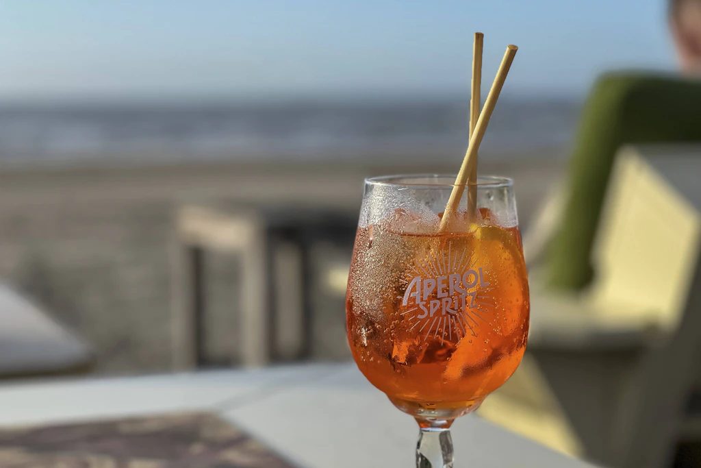 Ein Prosit auf die Infrastruktur! Aperol Spritz am Strand mit Meerblick. (Symbolbild)