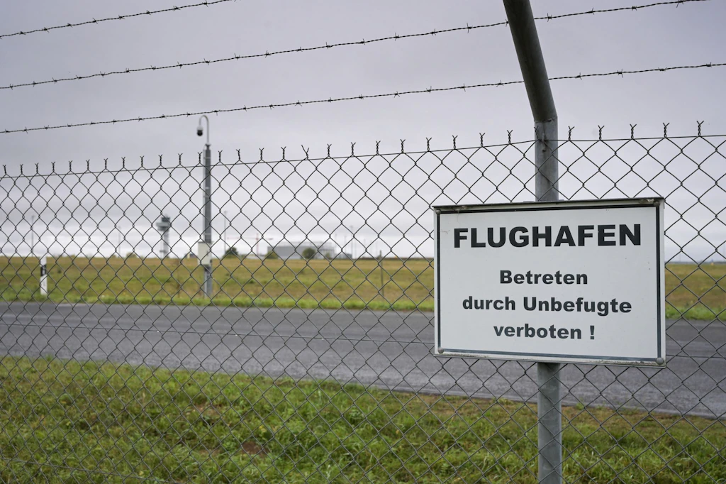 Zwei Männer durchbrechen eine Absperrung am Flughafen Leipzig/Halle.