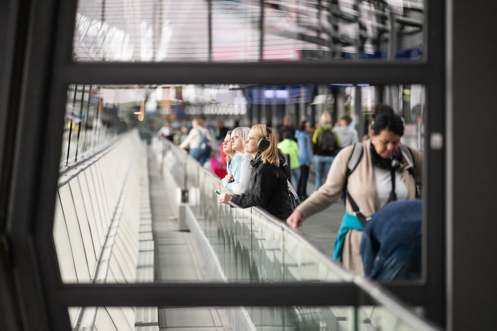 Fluggäste betrachten ein startendes Flugzeug am Flughafen Leipzig/Halle.