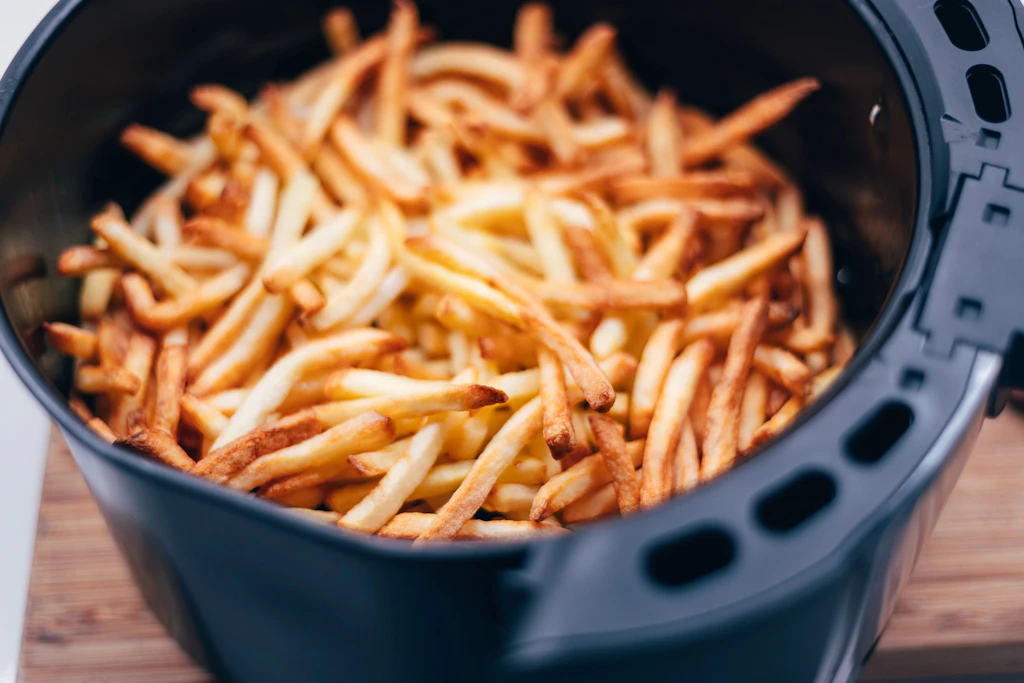 Pommes gelingen in der Heißluftfritteuse problemlos. Bei leichtem Blattgemüse wie Salat oder Spinat kann der Luftstrom dagegen zum Problem werden. (Symbolbild)