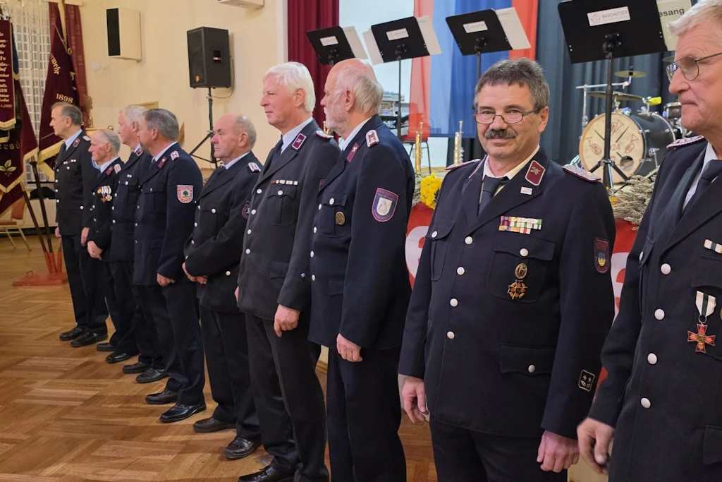 Feuerwehr-Ehrung in Pulsnitz: Mehrere Kameraden stehen im Schützenhaus für die Auszeichnung mit Ehrenzeichen und Ehrenkreuzen bereit.