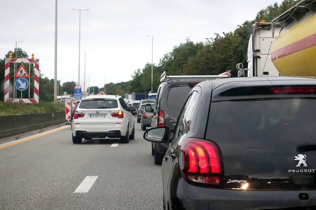Stau vor einer Autobahnbaustelle: Die Autos stehen dicht an dicht, am Rand kündigen Warnschilder die Verengung an. Wer wann die Spur wechseln darf, sorgt dabei immer wieder für Streit. (Symbolbild)
