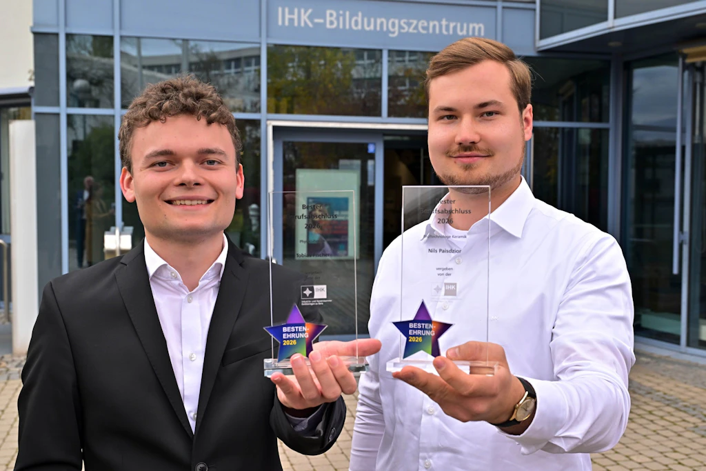 IHK-Bestenehrung in Gera: Tobias Fischer und Nils Paisdzor präsentieren ihre Auszeichnungen vor dem Bildungszentrum.