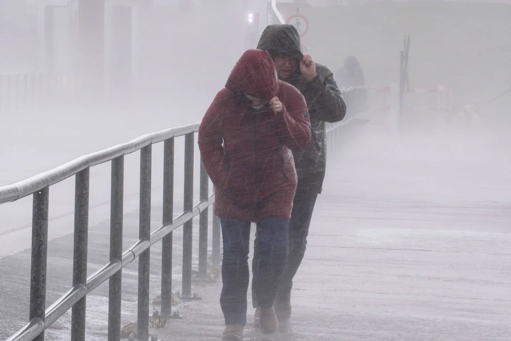 Kaum noch Sicht an der Küste: Zwei Menschen stemmen sich gegen Sturm Manja. An der Nordsee warnt der DWD bis Mitternacht vor Orkanböen bis 120 km/h.