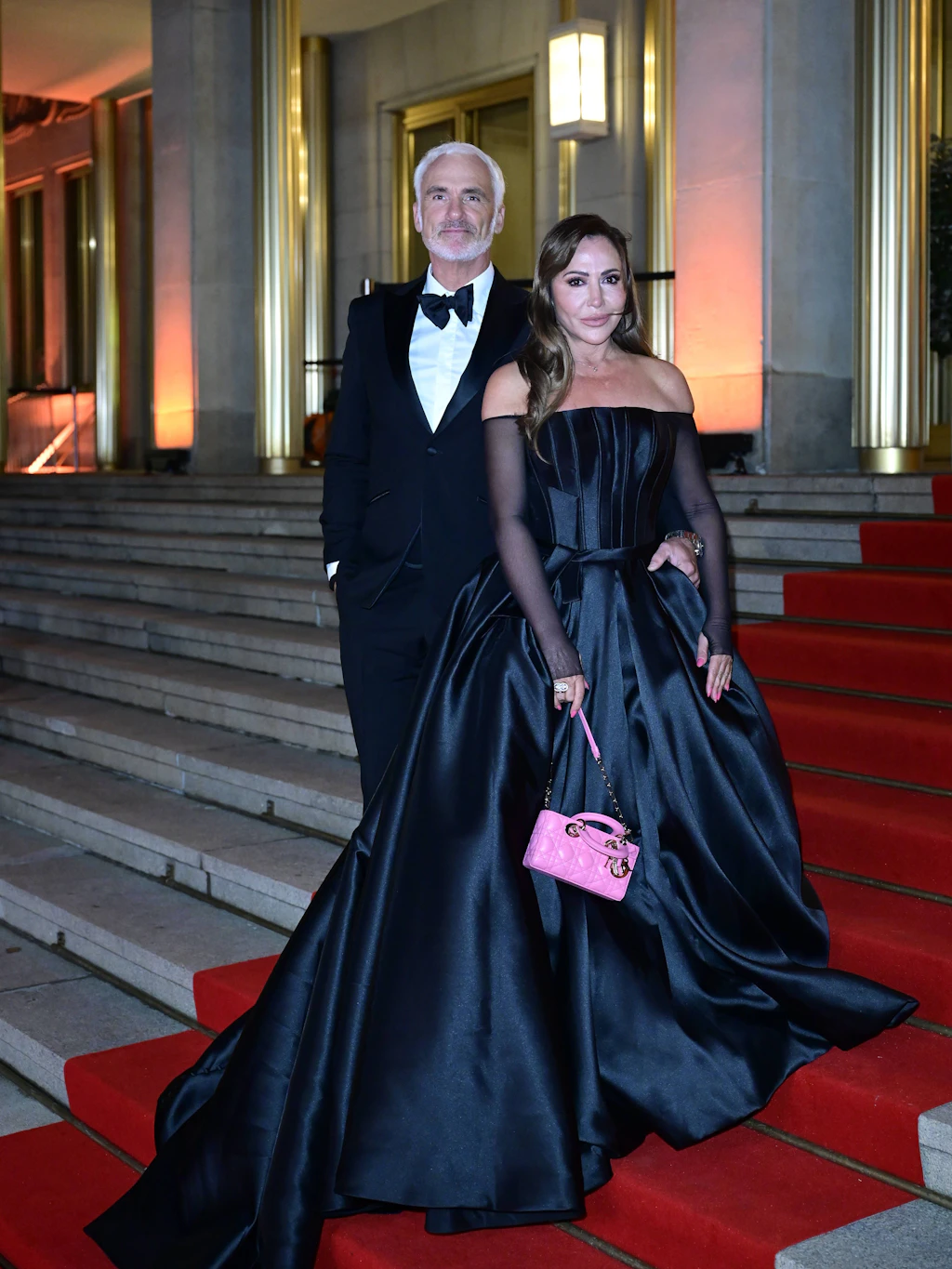 <strong>Flop</strong>: Simone Thomalla entsprach dem Dresscode des Abends allemal: „Black Tie“ gab der Veranstalter vor, also für die Damen ein bodenlanges Abendkleid oder eine schulterfreie Robe. Bodenlang, schulterfrei und elegant hakt die Schauspielerin in ihrem schwarzen, pompösen Prinzessinnenkleid von Óscar de la Renta souverän von der Liste ab. Der glänzende Stoff und die transparenten schwarzen Ärmel mit Aussparung für die Daumen wirken jedoch nicht ganz so glamourös. Die kleine pinke Tasche von <a href="https://www.berliner-zeitung.de/article/dior-cruise-2027-in-los-angeles-wie-jonathan-anderson-marlene-dietrich-aufleben-laesst-10036312">Dior</a> in ihrer Hand lässt die feine Waage zwischen Kitsch und Eleganz dann leider endgültig kippen.