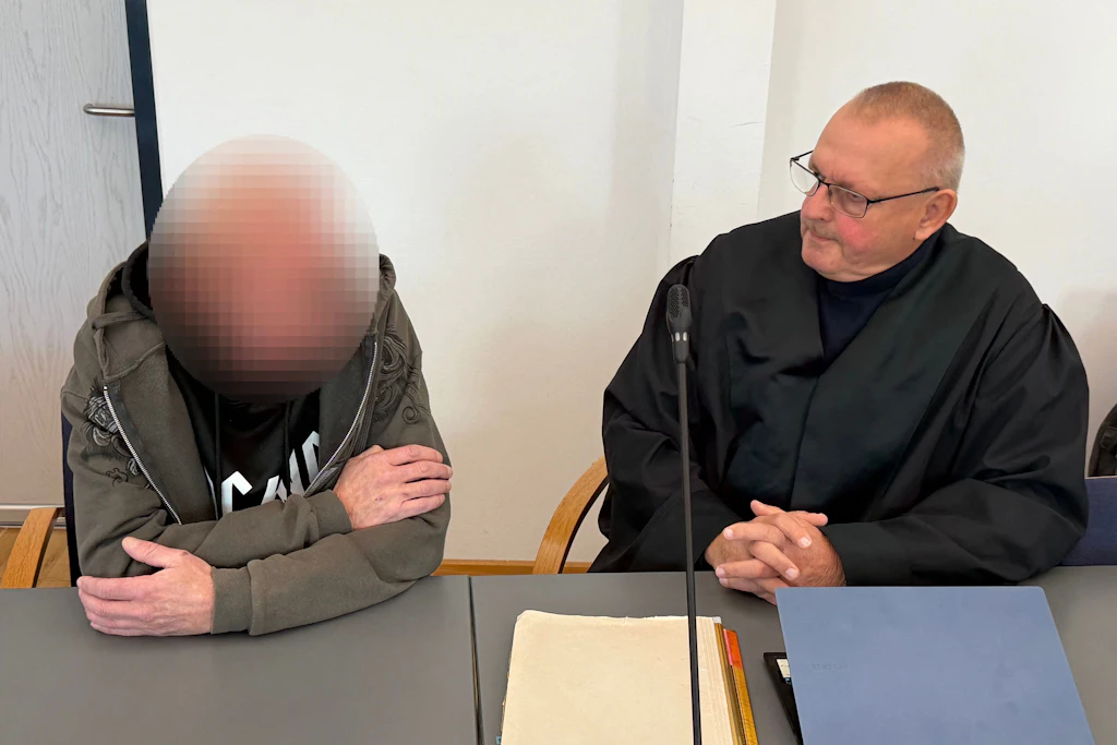 Der Angeklagte (l) sitzt mit seinem Anwalt im Gerichtsaal.