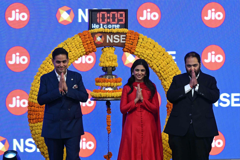 Akash, Isha und Anant Ambani (von links) feiern am 28. Oktober 2026 den Börsengang von Jio Platforms in Mumbai. Die Aktie legte zum Handelsstart um mehr als 21 Prozent zu.