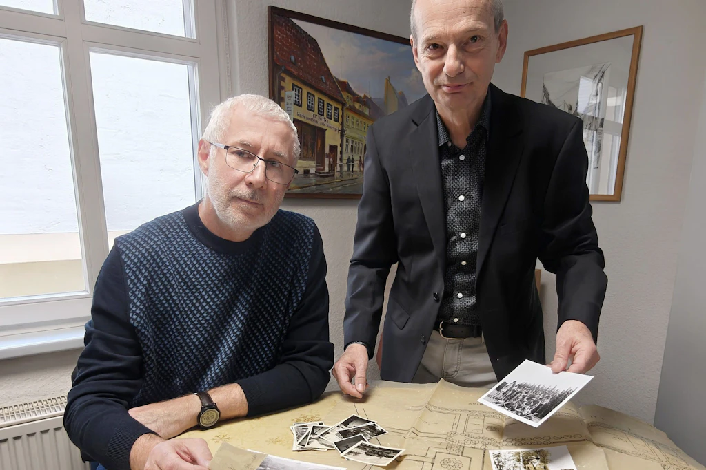 Museumszugang in Finsterwalde: Roland Rückert und Olaf Weber zeigen Fotos und einen Plan aus dem Nachlass von Rudolf Peters.