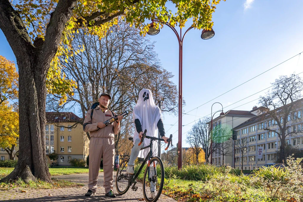 Gegen Geisterradeln in Erfurt: Eine Gestalt im Geisterkostüm steht mit einem Fahrrad auf einem Weg mit weißer Markierung.