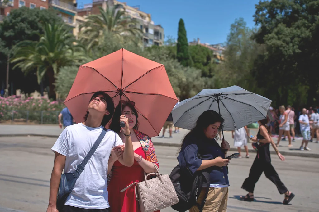 In Barcelona leiden Einheimische und Touristen gerade unter einer Hitzewelle: Manch einer schützt sich schon mit Schirmen vor der Sonne.