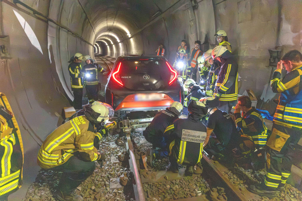 Feuerwehrleute arbeiten tief in dem Straßenbahntunnel in Bochum an dem Auto der Frau.